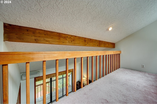 hall with carpet floors, a textured ceiling, and a wall unit AC