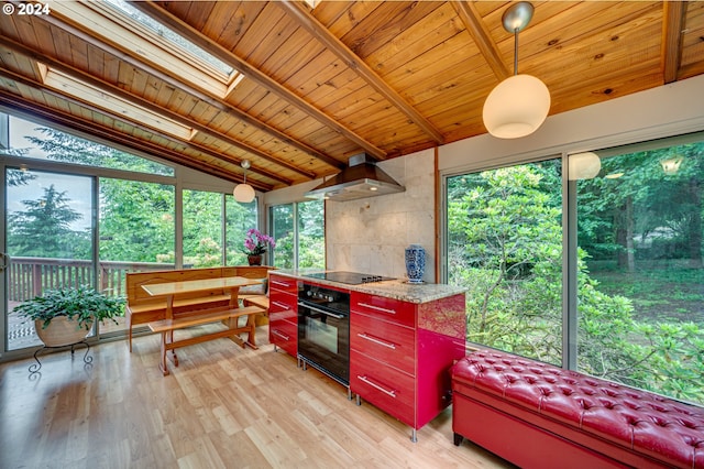 sunroom / solarium with vaulted ceiling with skylight and wooden ceiling