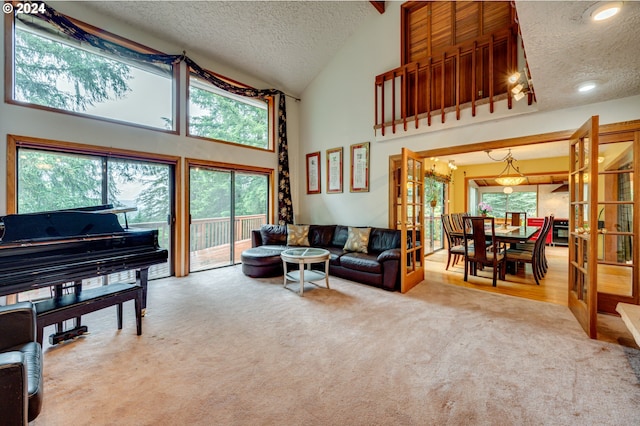 carpeted living room with french doors, a textured ceiling, and high vaulted ceiling