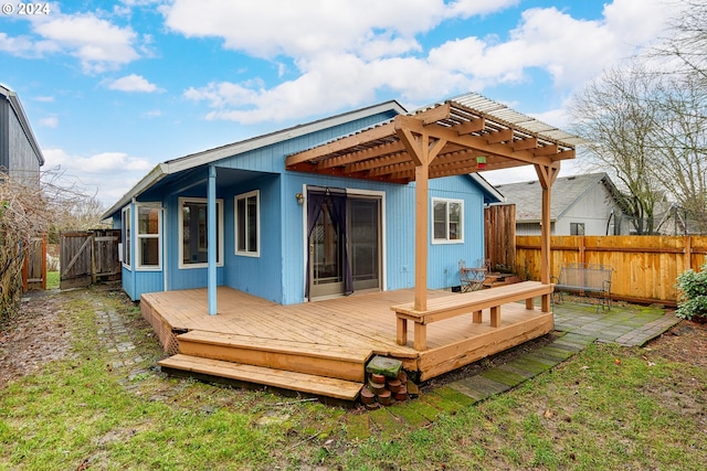 rear view of property featuring a pergola and a deck