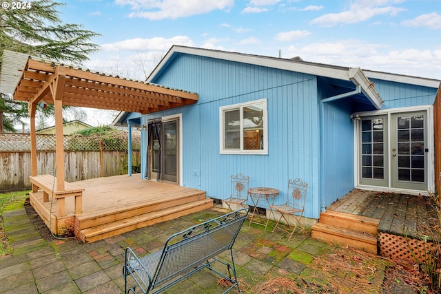 rear view of property featuring a pergola and a deck