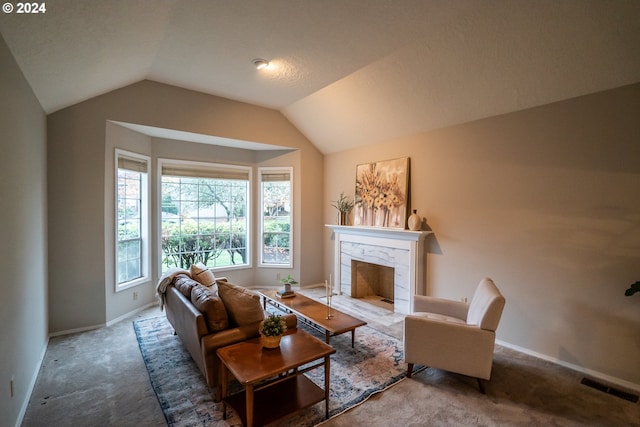 carpeted living room with a textured ceiling, a fireplace, and vaulted ceiling