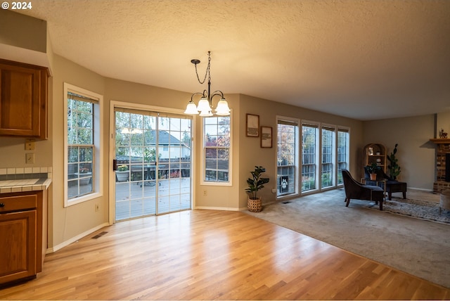 dining room with a healthy amount of sunlight, light wood-type flooring, and a chandelier