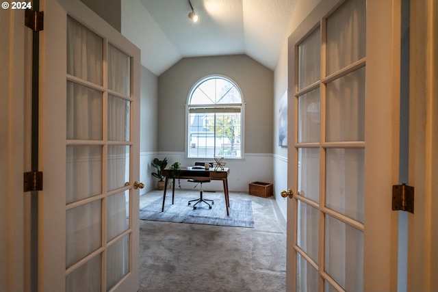 unfurnished office featuring carpet, french doors, and vaulted ceiling