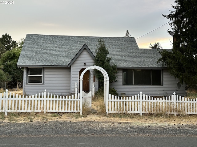 view of front of home featuring a fenced front yard and a shingled roof