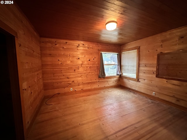 unfurnished room with wood walls, wooden ceiling, and wood finished floors