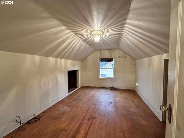 bonus room with baseboards, vaulted ceiling, and hardwood / wood-style flooring