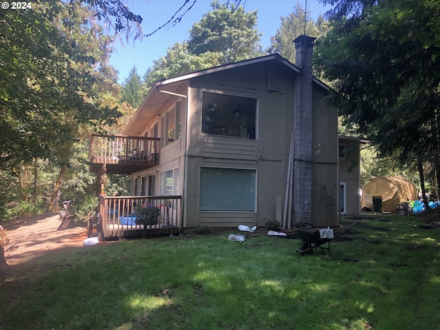 view of side of property featuring a lawn and a wooden deck