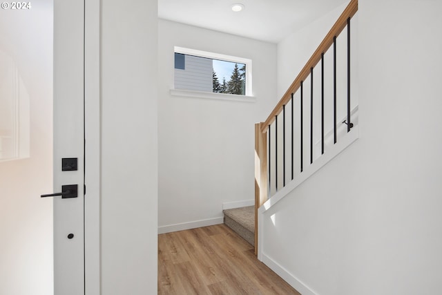 stairs with wood finished floors and baseboards