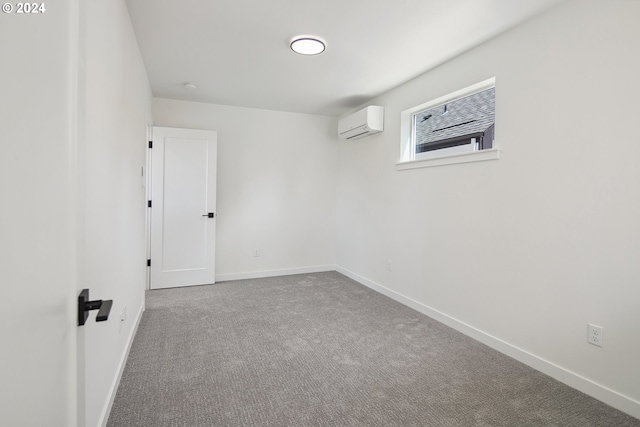 carpeted empty room featuring a wall unit AC and baseboards