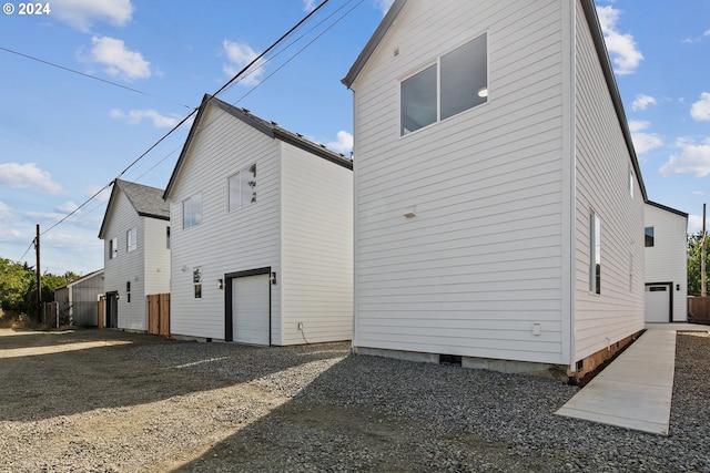 back of house with crawl space and gravel driveway