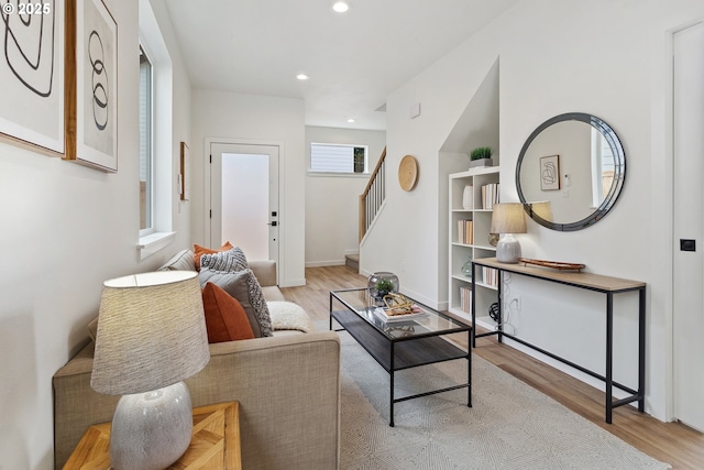 living area with stairs, baseboards, light wood-style flooring, and recessed lighting