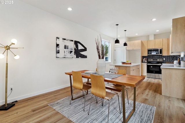 dining space featuring recessed lighting, light wood-style flooring, and baseboards