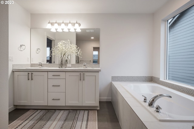 bathroom with tiled bath and vanity