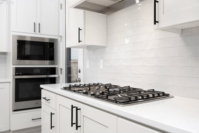 3104 S Kodiak St Unit Lt814, Cornelius, OR 97113 - kitchen featuring appliances with stainless steel finishes, range hood, light countertops, and tasteful backsplash