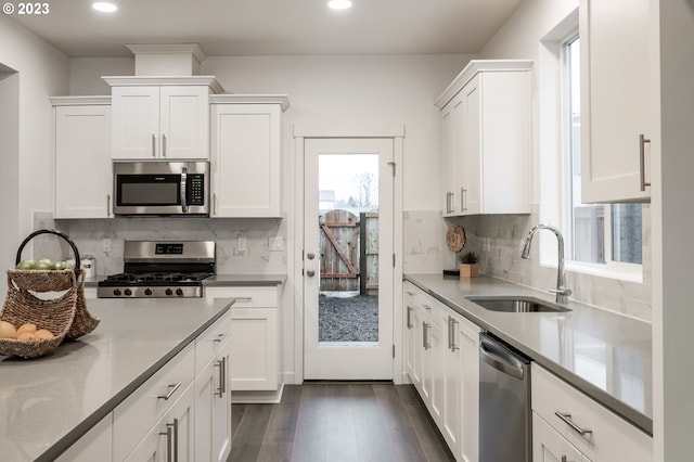 kitchen featuring dark hardwood / wood-style flooring, white cabinetry, sink, and stainless steel appliances