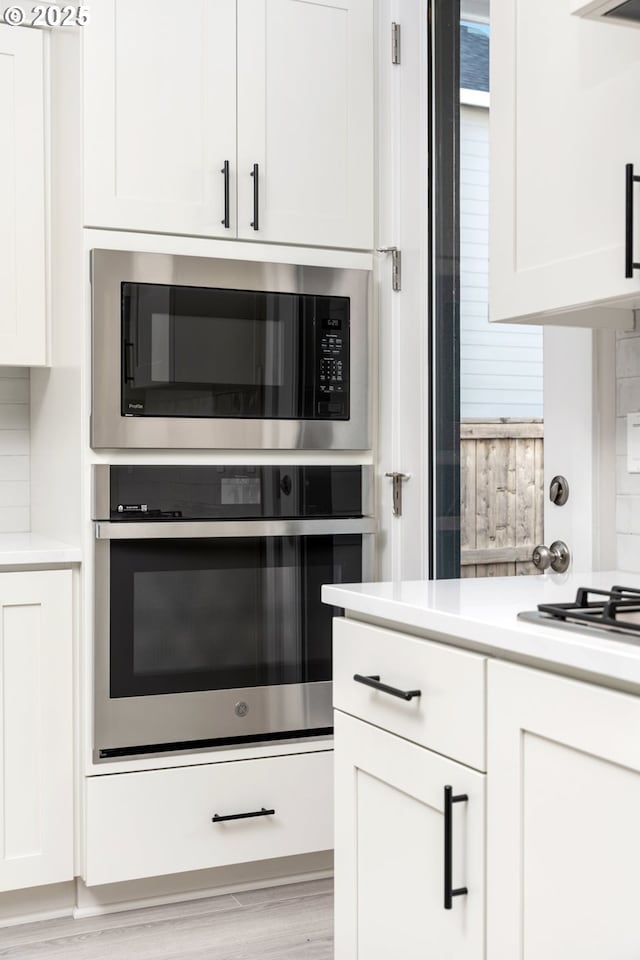 3104 S Kodiak St Unit Lt814, Cornelius, OR 97113 - kitchen with appliances with stainless steel finishes, light countertops, white cabinetry, and light wood-style floors