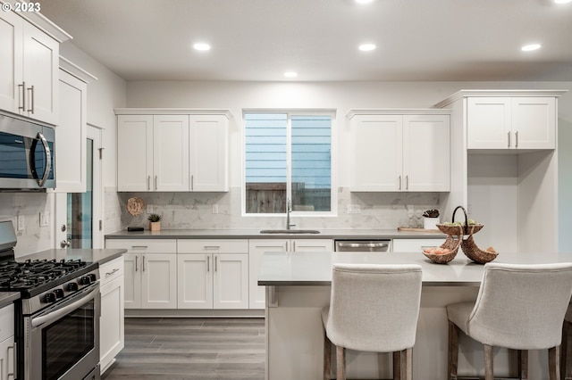 kitchen featuring white cabinets, stainless steel appliances, dark wood-type flooring, and sink