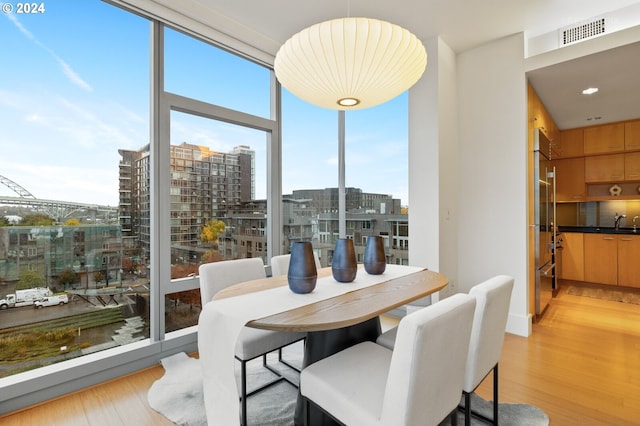 dining area with sink and light hardwood / wood-style flooring