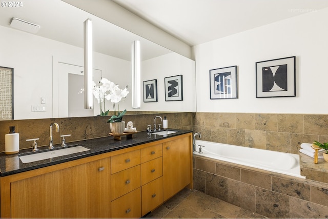 bathroom featuring tiled bath and vanity