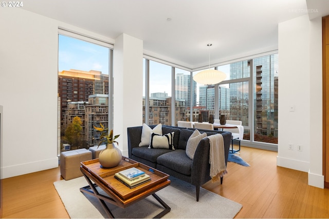 living room featuring expansive windows, a wealth of natural light, and light hardwood / wood-style floors