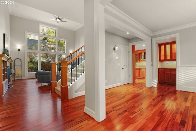 interior space with hardwood / wood-style floors, ceiling fan, and ornamental molding