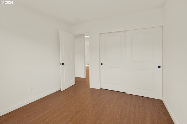 unfurnished bedroom featuring light hardwood / wood-style floors and a closet