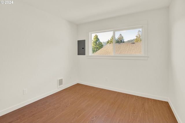 spare room featuring hardwood / wood-style flooring and electric panel