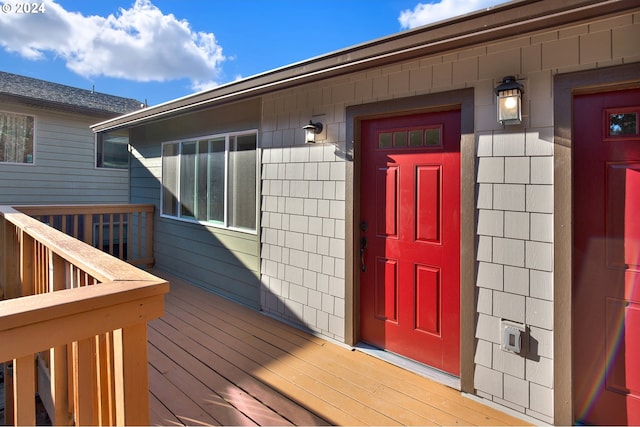 view of exterior entry featuring a wooden deck