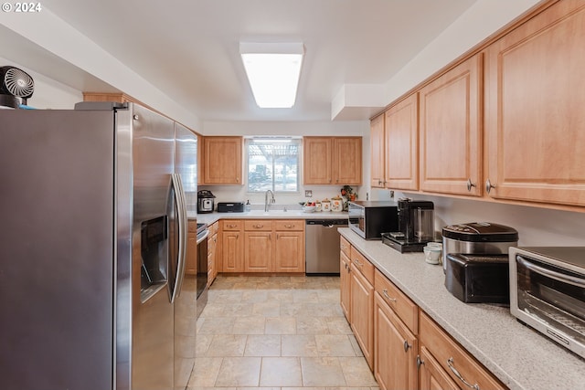 kitchen with light brown cabinets, stainless steel appliances, and sink