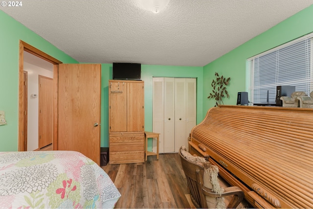 bedroom with a textured ceiling, hardwood / wood-style flooring, and a closet