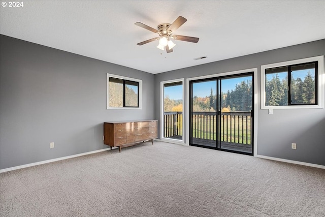 carpeted spare room with ceiling fan