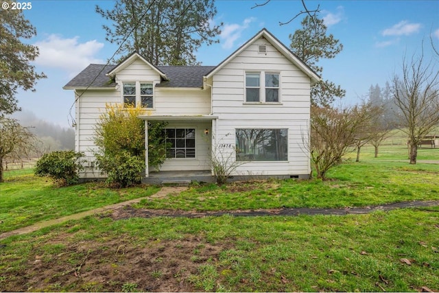 rear view of property featuring a lawn