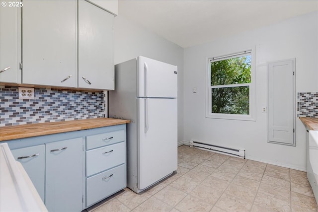 kitchen featuring white cabinetry, white refrigerator, decorative backsplash, and a baseboard heating unit