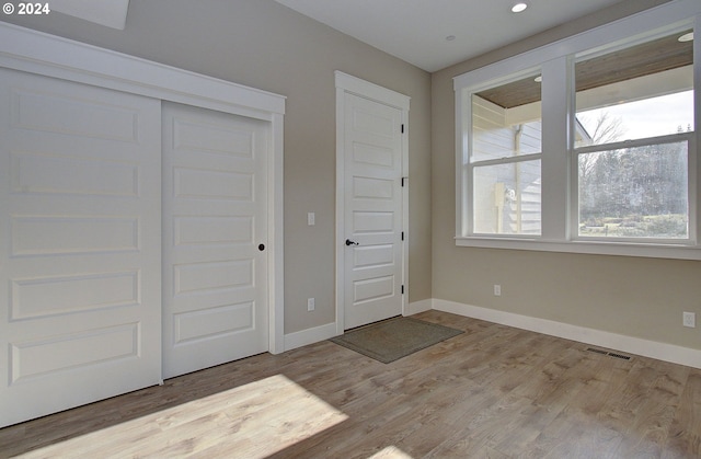 unfurnished bedroom featuring light wood-type flooring and a closet