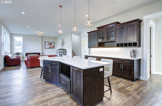 kitchen with pendant lighting, a kitchen breakfast bar, a center island, and tasteful backsplash