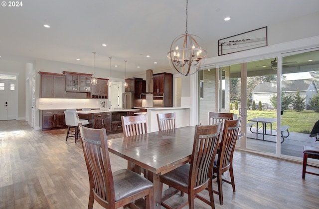 dining area with wood-type flooring and a notable chandelier