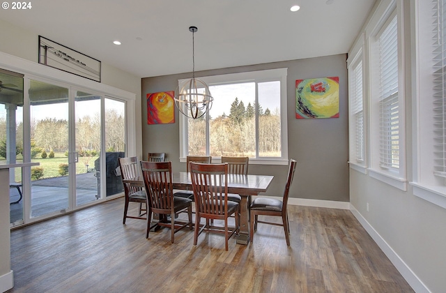 dining space with hardwood / wood-style floors and a notable chandelier