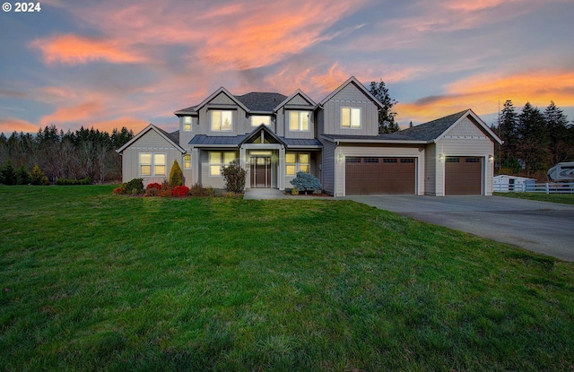 view of front of home with a yard and a garage