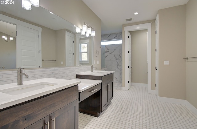 bathroom with backsplash, vanity, and tiled shower