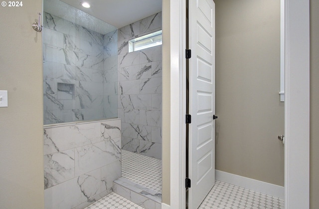 bathroom with tiled shower and tile patterned flooring