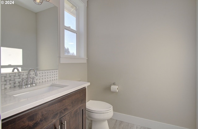 bathroom with decorative backsplash, vanity, and toilet