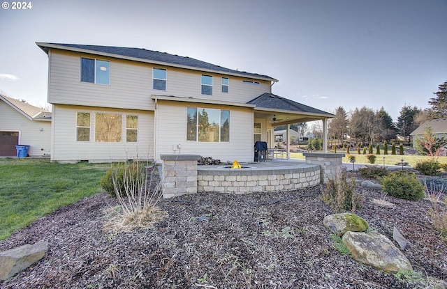 rear view of property with ceiling fan, a patio area, and a lawn