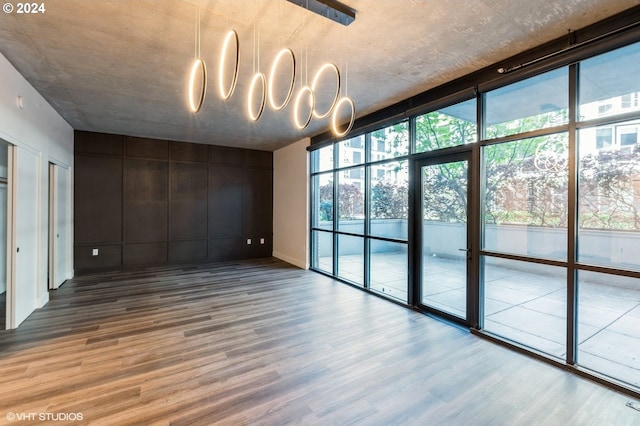 spare room with floor to ceiling windows and wood-type flooring