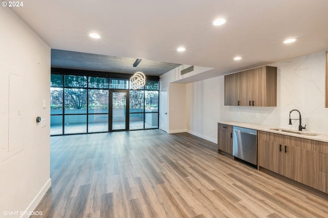 kitchen with dishwasher, light hardwood / wood-style floors, expansive windows, and sink