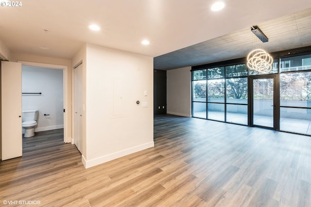 spare room featuring a wall of windows and wood-type flooring