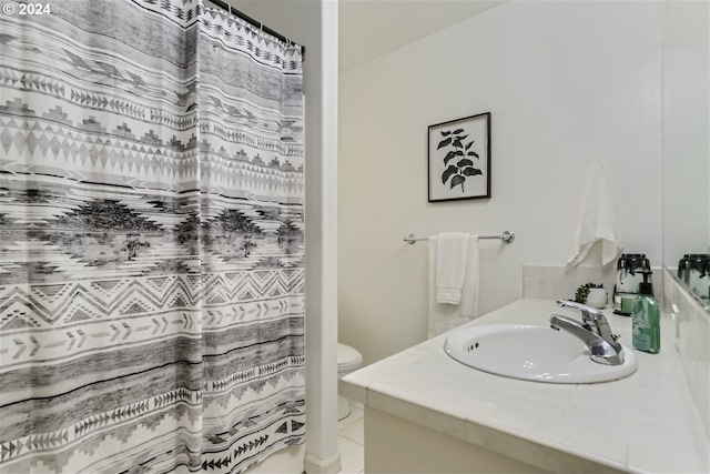 bathroom with toilet, vanity, and tile patterned floors