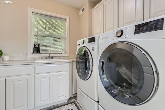 washroom featuring cabinets, independent washer and dryer, and sink