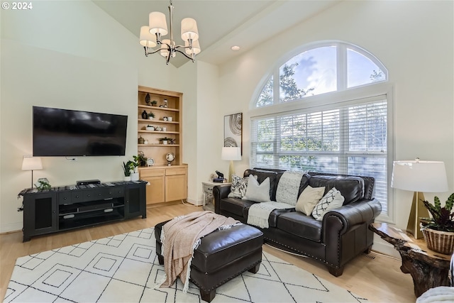 living room with light hardwood / wood-style flooring, high vaulted ceiling, and a chandelier