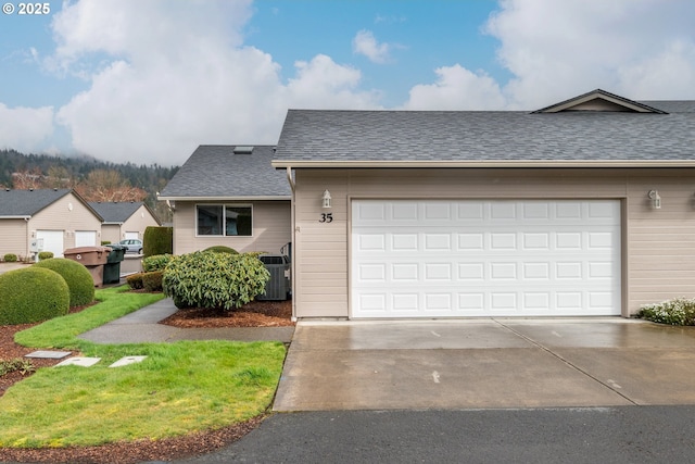 view of front of house featuring roof with shingles and driveway